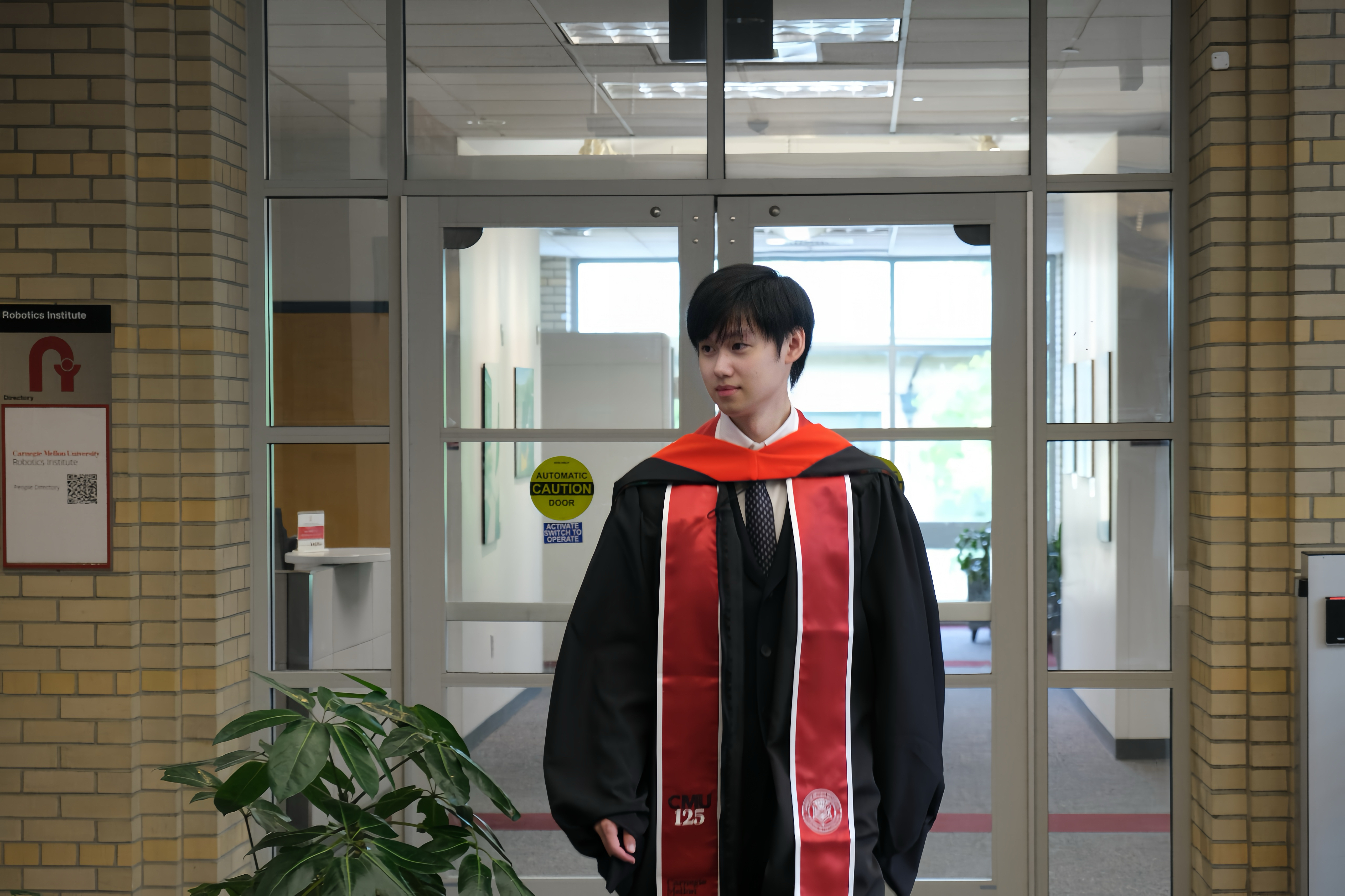 Lyuxing He in graduation regalia at the CMU Robotics Institute